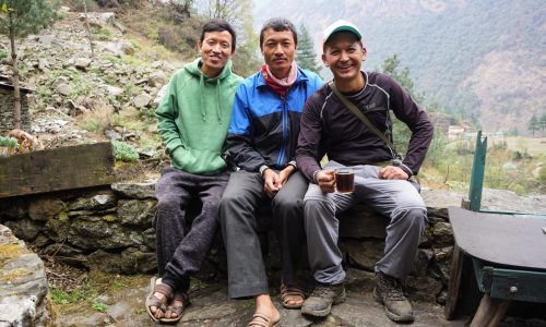 Nepal: Guide und Porter legen eine kurze Rast ein